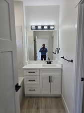 Bathroom featuring a bathtub, vanity, and light wood-style floors