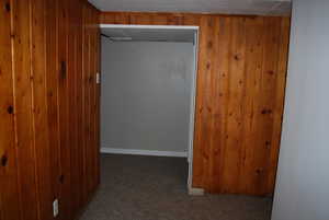 Hall with wooden walls and dark carpet