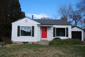Bungalow with a front lawn, roof with shingles, and board and batten siding