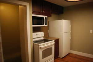 Kitchen with white appliances, dark wood finished floors, and dark brown cabinetry