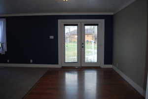 Empty room with french doors and dark wood finished floors
