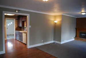 Unfurnished living room with dark wood-type flooring and a brick fireplace