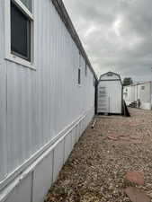 View of property exterior featuring a storage unit