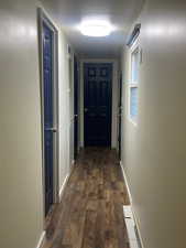 Corridor with dark wood-style floors and baseboards