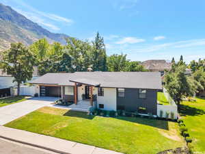 Ranch-style home with concrete driveway, roof with shingles, covered porch, and an attached garage