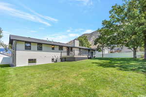 Back of house featuring a deck with mountain view, a chimney, and brick siding