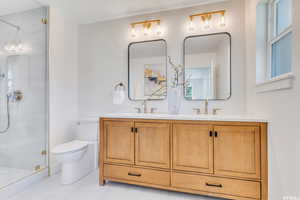 Bathroom featuring double vanity and a shower stall
