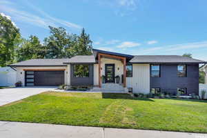 View of front of home with driveway, roof with shingles, and an attached garage