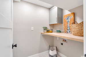 Laundry room featuring cabinet space, washer hookup, and a textured ceiling