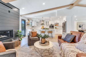 Living area with light wood-style flooring, a fireplace, recessed lighting, and wooden walls