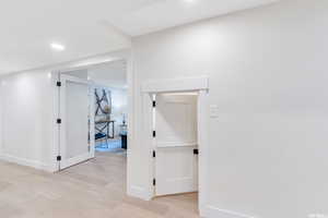Hallway featuring light wood-style flooring and recessed lighting