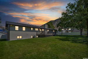 Back of house featuring a wooden deck, brick siding, and a chimney