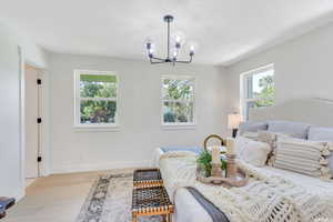 Bedroom with wood finished floors, a chandelier, and a textured ceiling