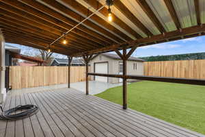 Deck with an outdoor structure and a fenced backyard