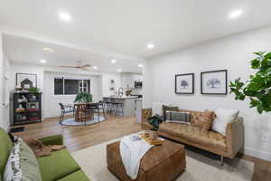 Living room featuring a ceiling fan, recessed lighting, and light wood-style flooring