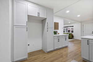 Kitchen featuring light wood-style flooring, recessed lighting, and white cabinets