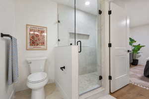Bathroom featuring a shower stall and baseboards