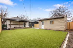 Back of house with a fenced backyard, a gazebo, brick siding, and an outdoor structure