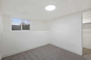 Unfurnished bedroom with a walk in closet and carpet floors