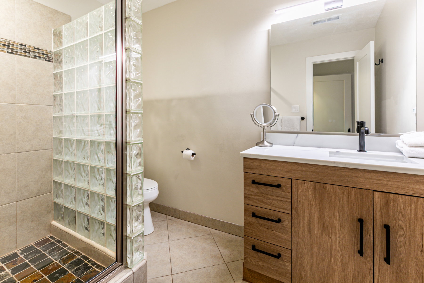 Full bathroom featuring vanity, walk in shower, and light tile patterned flooring