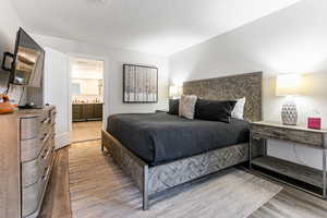 Bedroom featuring connected bathroom and light wood-style flooring