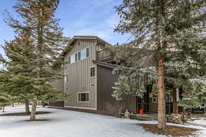 View of snowy exterior with a patio area and a balcony