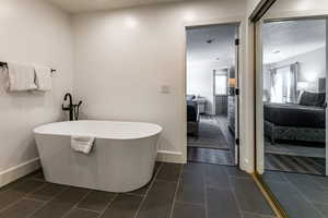 Ensuite bathroom with a soaking tub and a textured ceiling