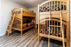 Bedroom featuring a textured ceiling and wood finished floors