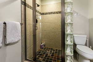 Bathroom featuring toilet and a stall shower