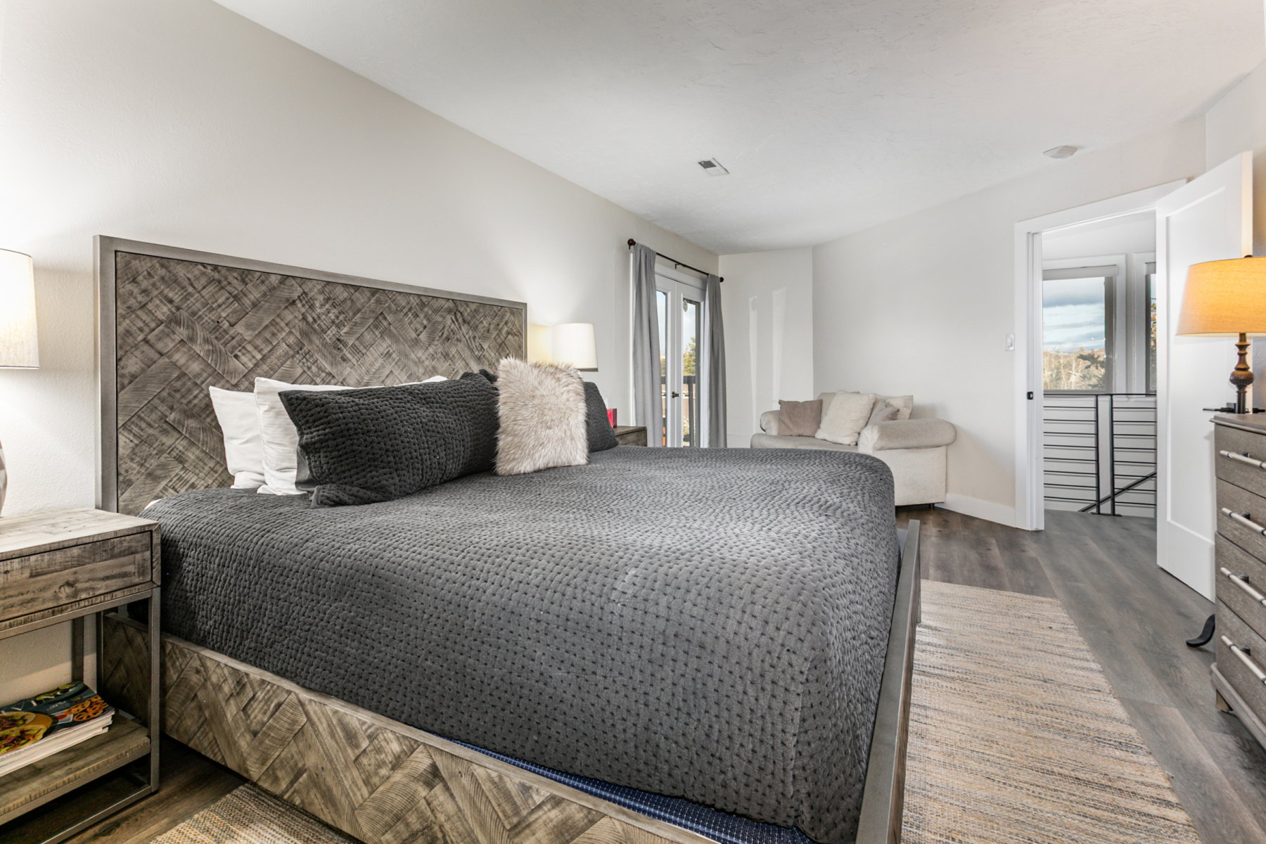 Bedroom featuring dark wood-type flooring, multiple windows, and access to outside