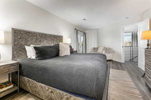 Bedroom featuring dark wood-type flooring, multiple windows, and access to outside