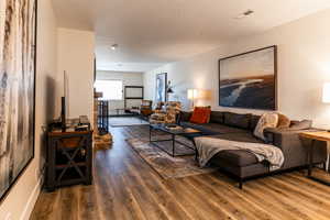 Living room with a textured ceiling and dark wood-style floors