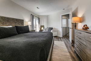 Bedroom featuring dark wood-type flooring and a textured ceiling