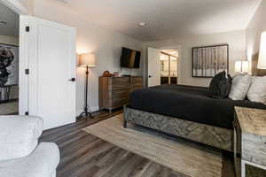 Bedroom with dark wood finished floors and a textured ceiling