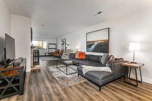Living room with dark wood-style floors and a textured ceiling