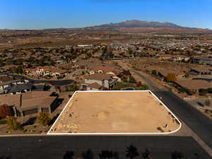 Aerial view of residential area featuring a mountain backdrop and property parcel outlined
