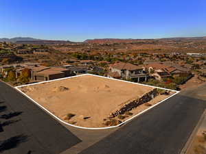 Aerial perspective of suburban area with property parcel outlined and a mountainous background