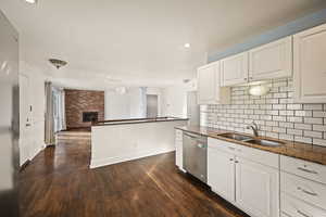 Kitchen featuring dark stone countertops, white cabinetry, recessed lighting, dark wood finished floors, and appliances with stainless steel finishes