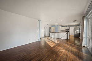 Unfurnished living room with dark wood finished floors, attic access, and recessed lighting