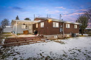 Rear view of property featuring a patio area, ceiling fan, and brick siding
