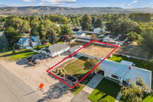 Aerial perspective of suburban area featuring a mountain backdrop and property parcel outlined