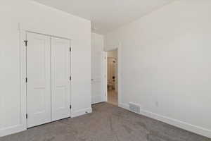 Unfurnished bedroom with carpet flooring and a closet