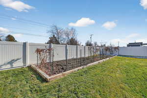 Fenced backyard featuring a garden space.
