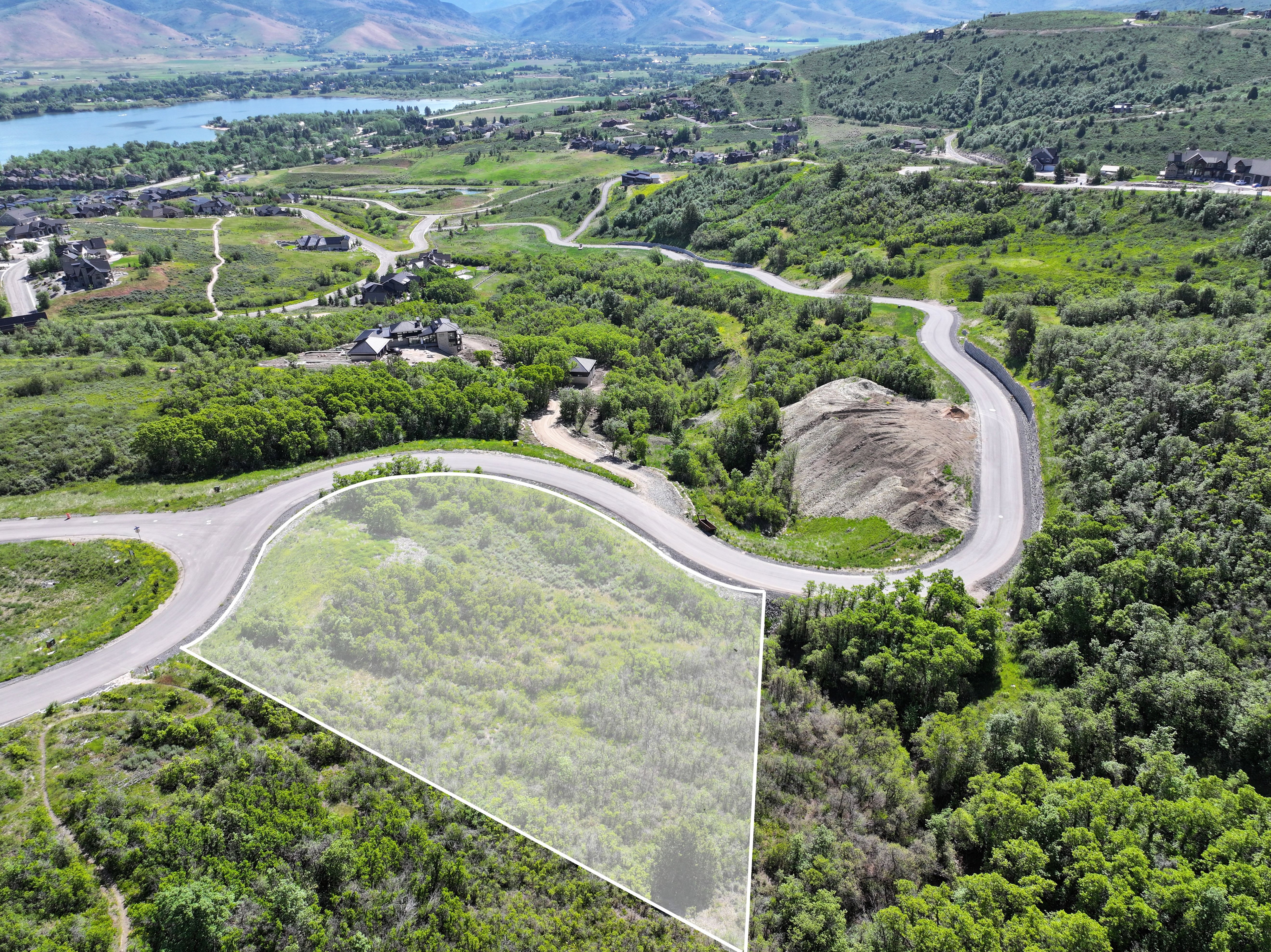 Expansive parcel featuring natural vegetation, bordered by paved roadways
