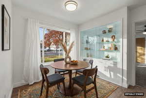 Dining space featuring dark wood-style flooring and baseboards