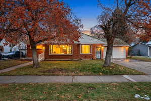 View of front facade with brick siding, a front lawn, and driveway