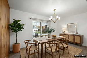 Dining room featuring dark carpet and a chandelier