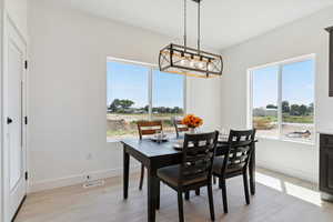Dining room featuring light wood-type flooring and healthy amount of natural light