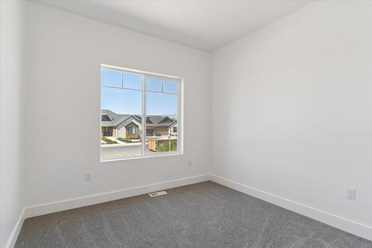 Spare room with dark colored carpet and a residential view