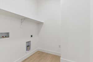 Laundry room with light wood-style floors, hookup for a washing machine, and electric dryer hookup
